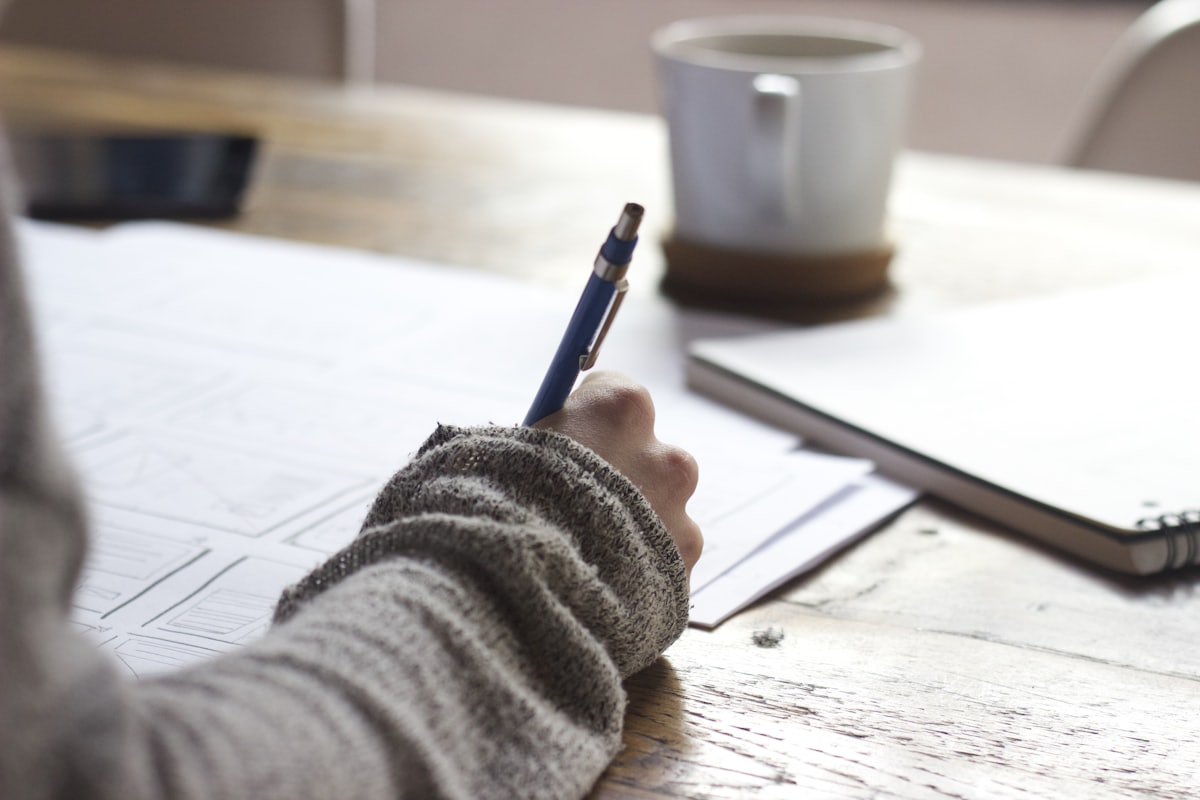 Handschriftliche Notizen neben einer Kaffeetasse
