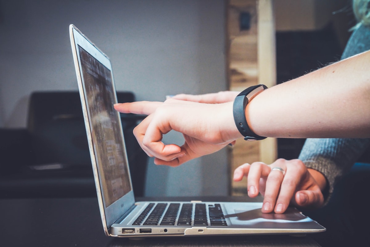 Eine Person zeigt auf einen Laptop-Bildschirm