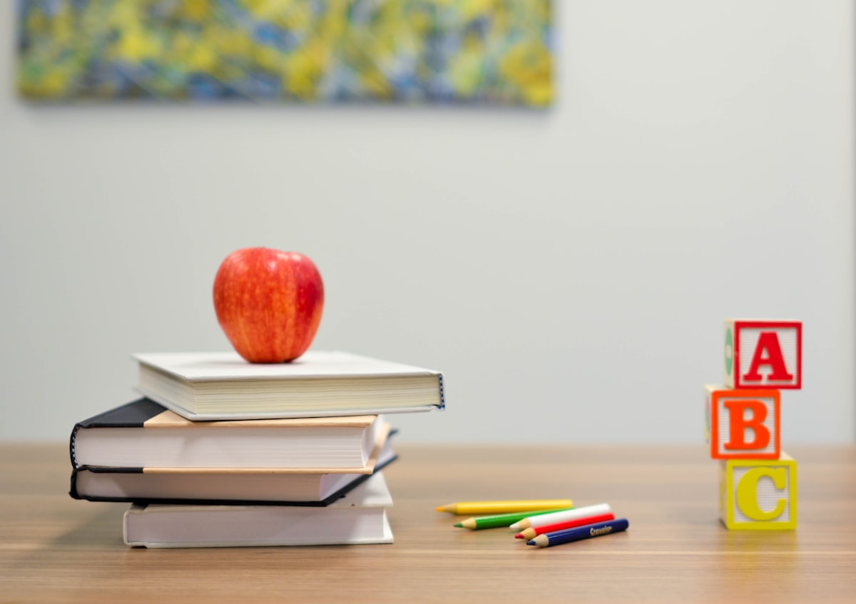 Schulbücher, Apfel und ABC-Würfel